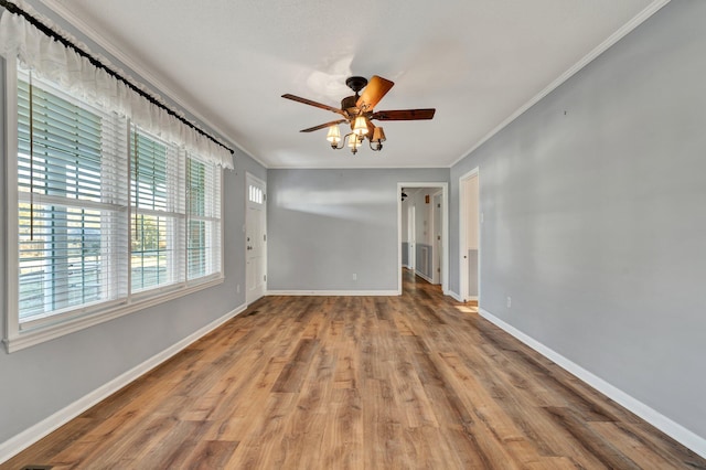 empty room featuring ceiling fan, hardwood / wood-style floors, and crown molding