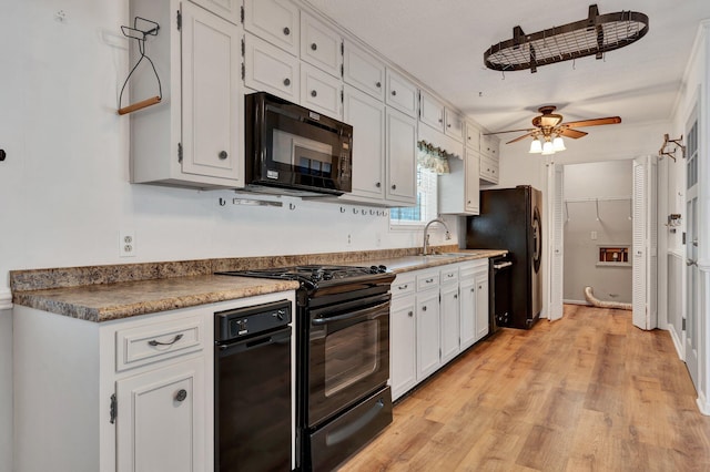 kitchen with ceiling fan, light hardwood / wood-style floors, black appliances, sink, and white cabinets