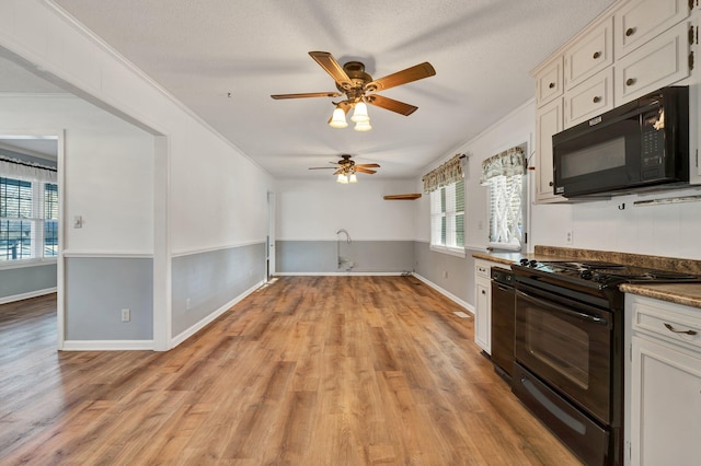 kitchen with ceiling fan, white cabinets, black appliances, and crown molding