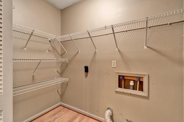 washroom with wood-type flooring and hookup for a washing machine