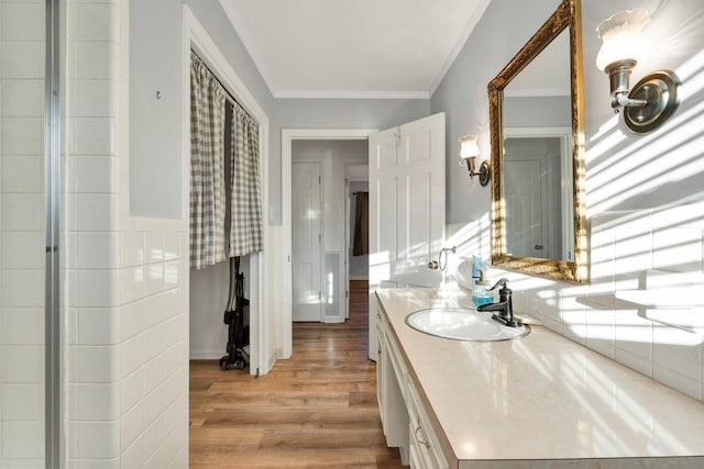 bathroom with ornamental molding, wood-type flooring, and vanity