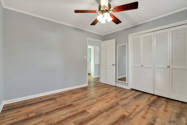 unfurnished bedroom featuring ceiling fan, crown molding, light hardwood / wood-style flooring, and a closet