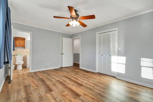 unfurnished bedroom with ceiling fan, ensuite bath, light wood-type flooring, a closet, and ornamental molding