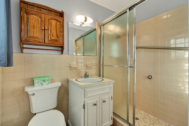 bathroom with vanity, ornamental molding, tile walls, and walk in shower