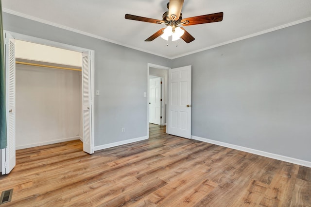 unfurnished bedroom with ceiling fan, a closet, light hardwood / wood-style flooring, and ornamental molding