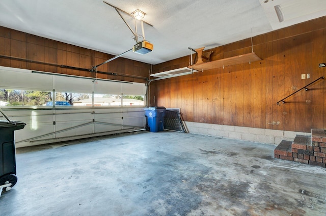 garage featuring wood walls and a garage door opener