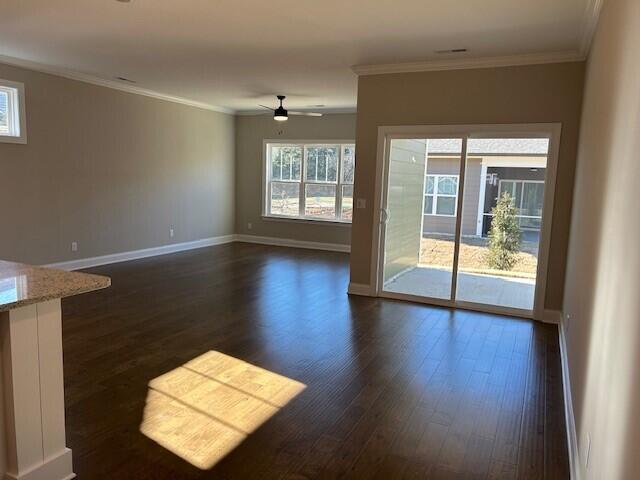 unfurnished living room featuring ceiling fan, dark hardwood / wood-style flooring, and crown molding