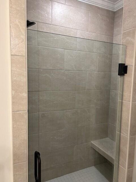 bathroom featuring an enclosed shower and ornamental molding