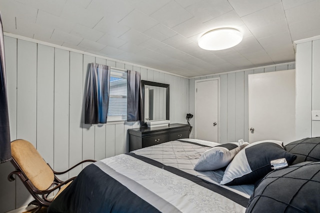 bedroom with wooden walls and ornamental molding