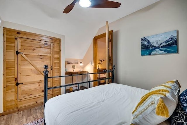 bedroom with lofted ceiling, hardwood / wood-style floors, and ceiling fan