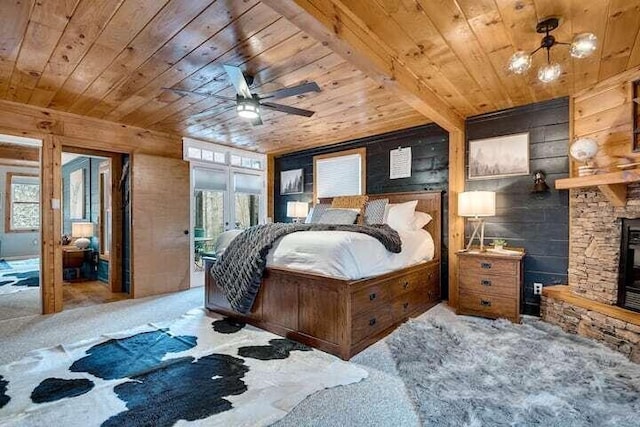 bedroom featuring ceiling fan, a stone fireplace, and carpet