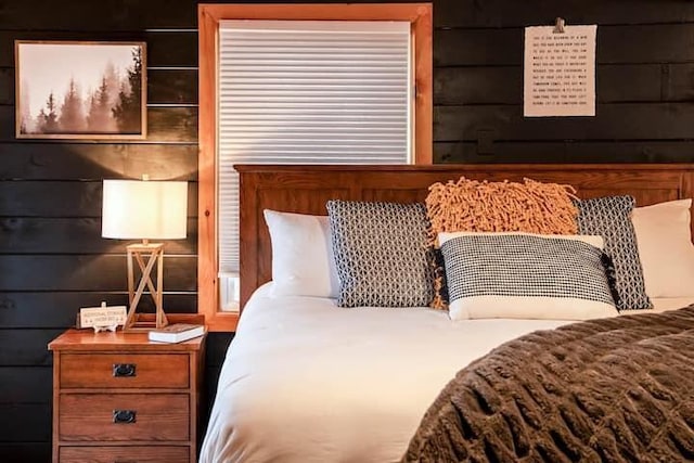 bedroom featuring wood walls