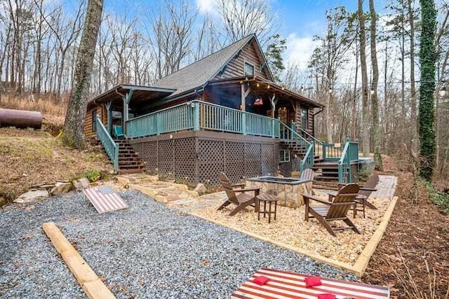 exterior space featuring a wooden deck and an outdoor fire pit