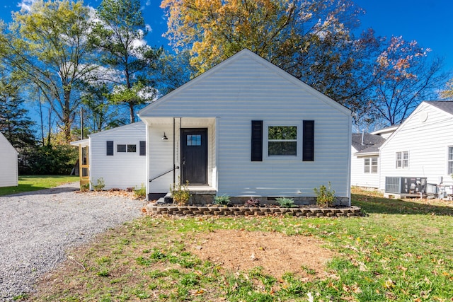 bungalow-style house featuring a front lawn and cooling unit