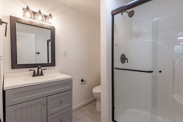 bathroom featuring a shower with shower door, vanity, tile patterned floors, and toilet