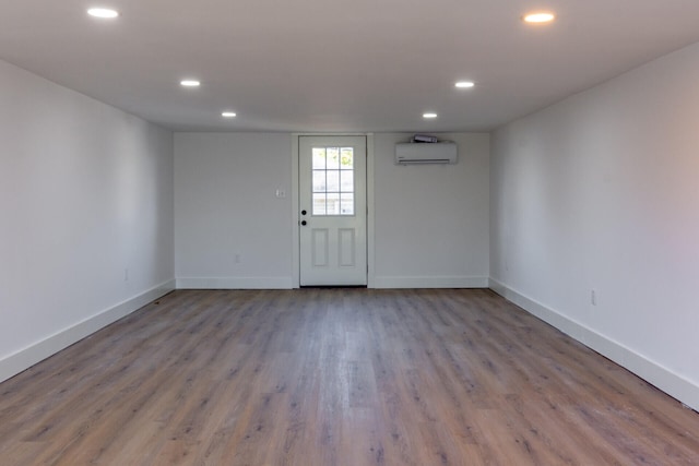 empty room featuring light wood-type flooring and a wall mounted AC