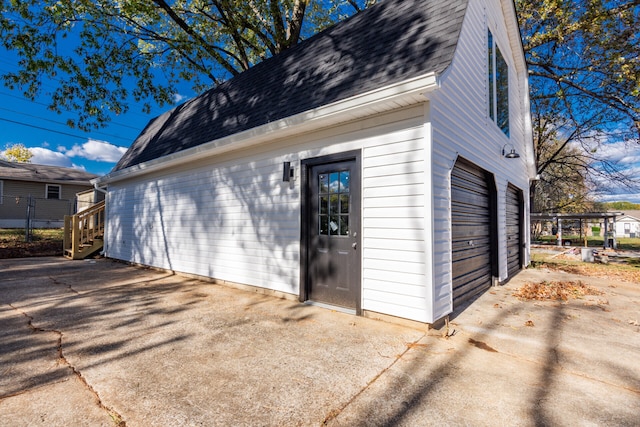 exterior space featuring a garage and an outbuilding