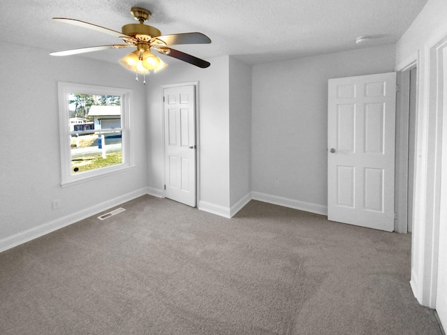 unfurnished bedroom featuring ceiling fan, a textured ceiling, and light carpet