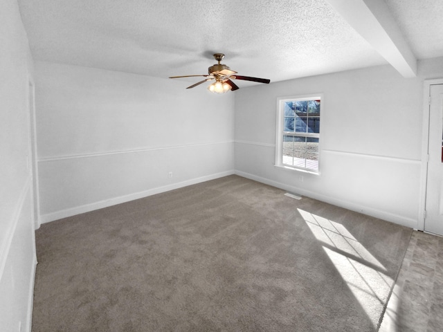 unfurnished room featuring a textured ceiling, carpet floors, beam ceiling, and ceiling fan