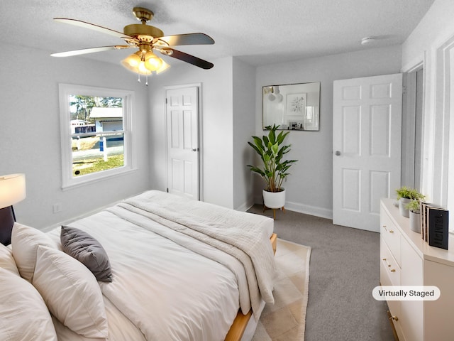 bedroom featuring a textured ceiling, light colored carpet, and ceiling fan