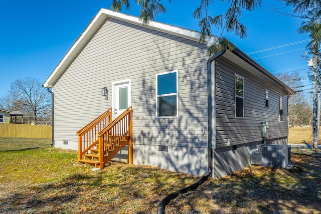 rear view of property featuring a yard and central AC