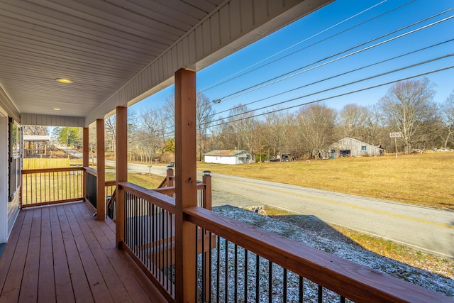 wooden terrace featuring covered porch and a yard