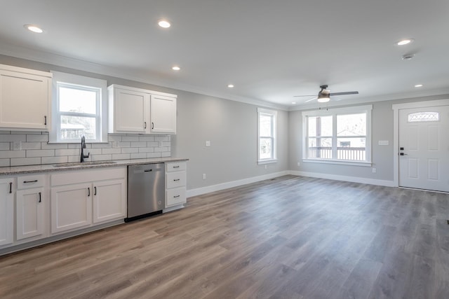 kitchen with white cabinetry, tasteful backsplash, sink, hardwood / wood-style flooring, and stainless steel dishwasher