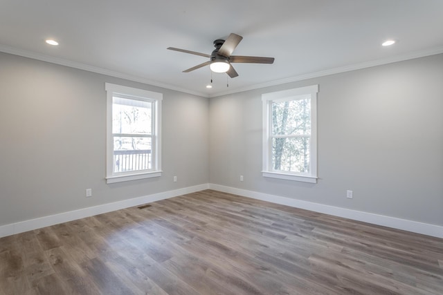 spare room featuring a wealth of natural light, ornamental molding, and wood-type flooring