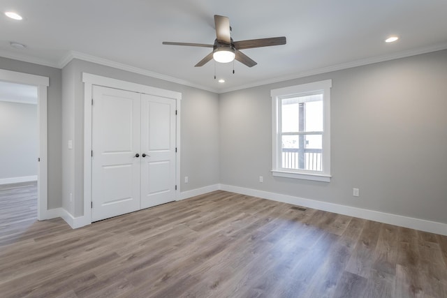 unfurnished bedroom with ceiling fan, a closet, light wood-type flooring, and ornamental molding