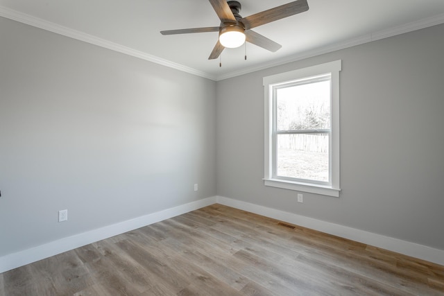 empty room featuring ceiling fan, light wood-type flooring, and ornamental molding