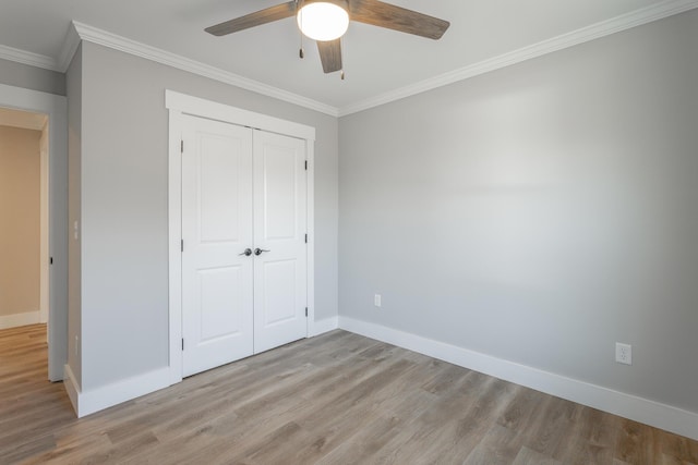 unfurnished bedroom featuring light wood-type flooring, ceiling fan, ornamental molding, and a closet