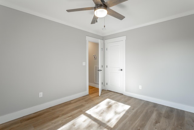 unfurnished room with ceiling fan, light wood-type flooring, and ornamental molding