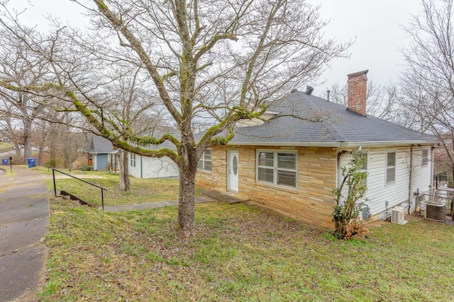 view of home's exterior with cooling unit and a lawn