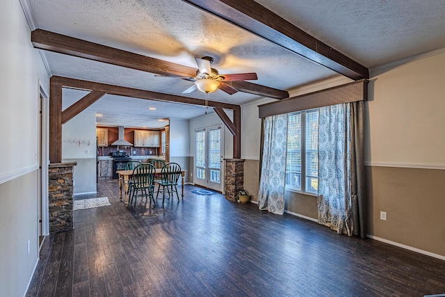 dining area with dark wood-type flooring, a textured ceiling, ornamental molding, beamed ceiling, and ceiling fan