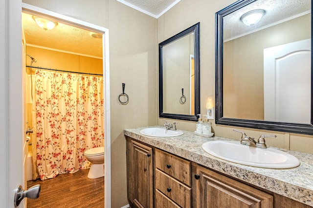 full bathroom featuring toilet, crown molding, a textured ceiling, vanity, and hardwood / wood-style floors