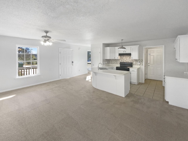 kitchen featuring pendant lighting, black electric range oven, sink, white cabinets, and light colored carpet