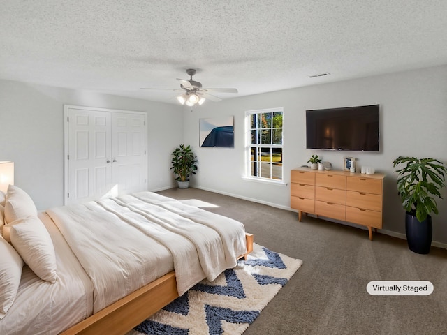 carpeted bedroom with a closet, ceiling fan, and a textured ceiling