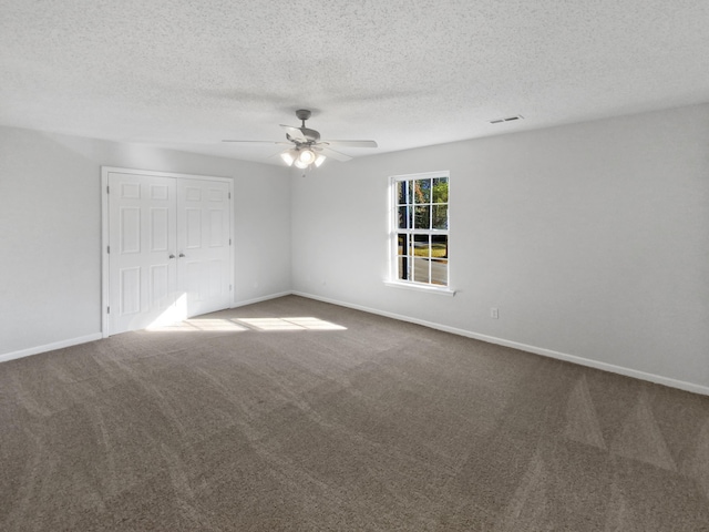 unfurnished room featuring a textured ceiling, carpet flooring, and ceiling fan