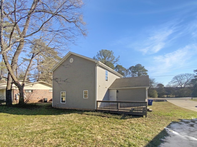 view of home's exterior featuring a wooden deck, central AC unit, and a yard