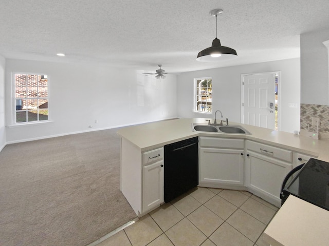 kitchen featuring dishwasher, hanging light fixtures, sink, white cabinets, and light colored carpet