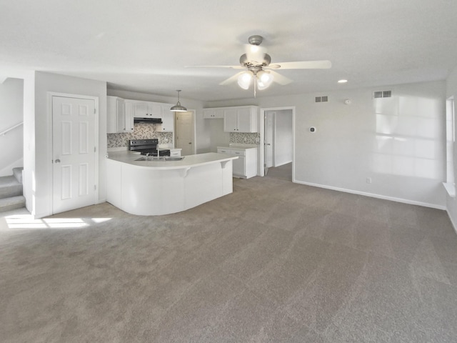 kitchen with tasteful backsplash, white cabinetry, kitchen peninsula, pendant lighting, and black electric range