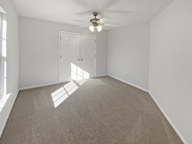 unfurnished room featuring ceiling fan, a textured ceiling, and carpet