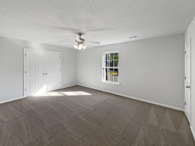 unfurnished bedroom with a closet, ceiling fan, carpet, and a textured ceiling