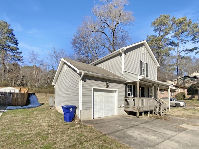 view of side of property featuring covered porch, a yard, and a garage