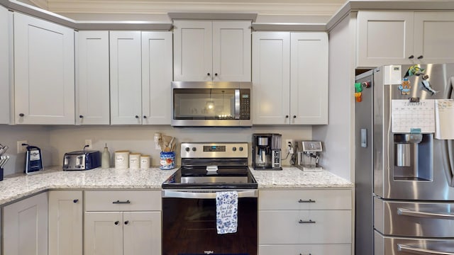 kitchen featuring light stone countertops, white cabinetry, and stainless steel appliances