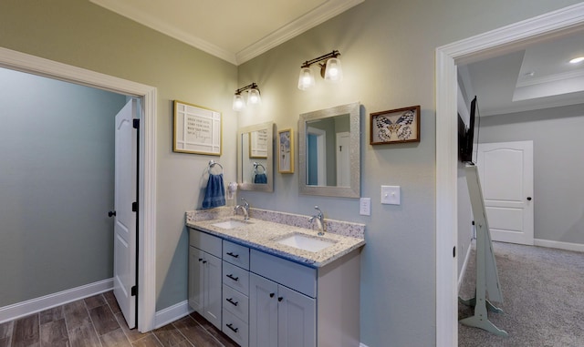 bathroom with vanity, ornamental molding, and a raised ceiling