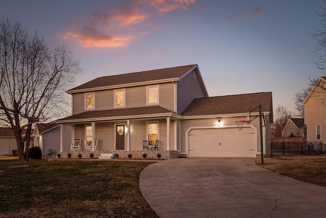 view of front of house with a yard, a porch, and a garage