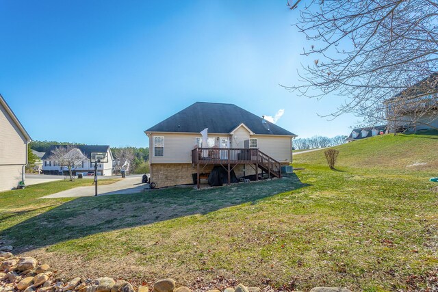 back of house featuring a lawn and a deck