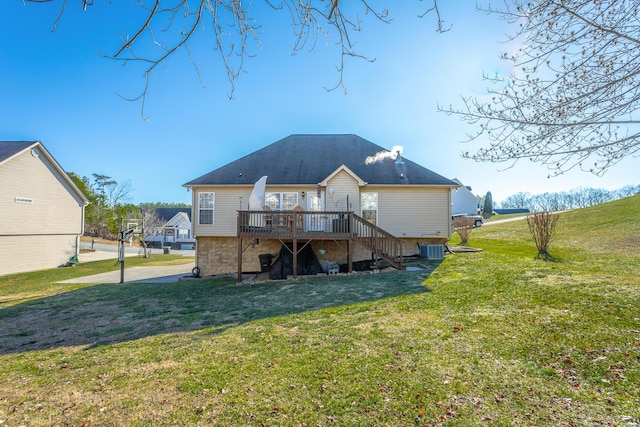 rear view of house with a deck, a lawn, and central AC