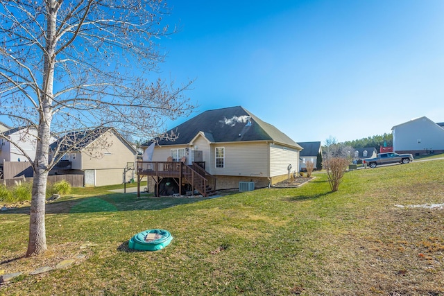 rear view of property featuring a deck, a yard, and central AC